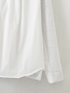 Detail of white and grey contrast stitching and fabric texture on a casual hoodie