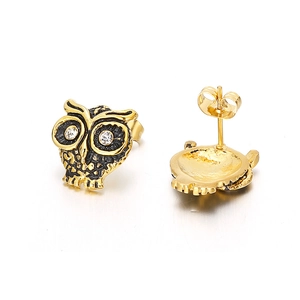 Boucles d'oreilles chouette dorées avec émail noir et yeux en zircon sur fond blanc