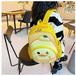 Detailed back view of a yellow 3D duck cartoon backpack worn by a toddler in a cafe