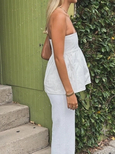 Détail d'un haut bustier blanc et d'un pantalon assorti dans un style de vacances élégant