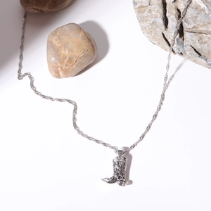 Nahaufnahme von Vintage-Silber-Cowboystiefel-Anhänger an Kordelkette mit Natursteinen