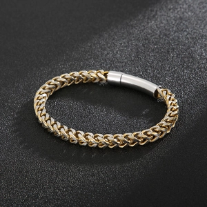 Detail of two-tone gold and silver wheat chain bracelet with a cylindrical clasp