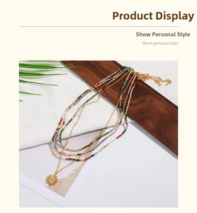 Detail of bohemian layered necklace with colorful beads and golden sun eye pendant