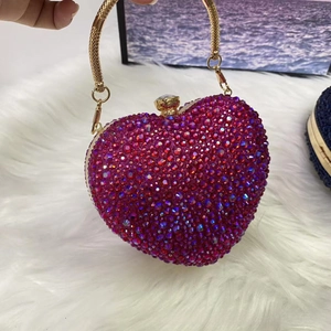 Detail of fuchsia rhinestone heart evening bag with gold handle and bead clasp