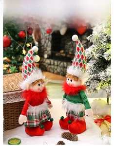 Detail view of plush Christmas elf dolls with telescopic legs in festive interior setting