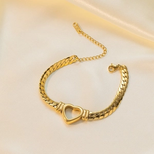 Detail of gold Cuban chain bracelet with hollow heart pendant on beige silk background