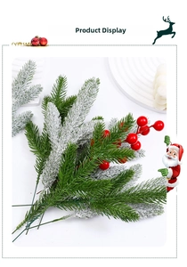 Close-up of artificial pine needles with white snow flocking and red winter berries
