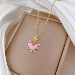 Pendentif papillon rose avec zircons et chaîne en acier doré sur soie blanche