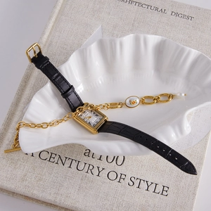 Vue détaillée d'une montre rectangulaire dorée avec bracelet cuir et gourmette fleurie