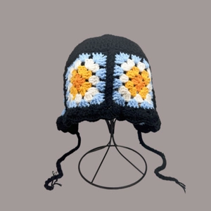 Detaillierte Nahaufnahme des handgemachten Häkelblumenmusters auf der Strickmütze