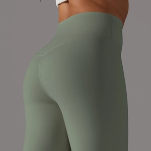 Close-up of high-waisted sage green yoga leggings with curved seams for butt lifting