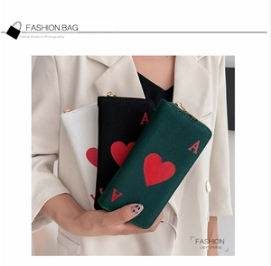 Detailed view of canvas Ace of Hearts zip wallets in dark green, black, and white colors