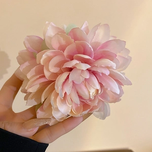 Close-up of handmade pink gradient fabric lotus flower hair claw with layered petals