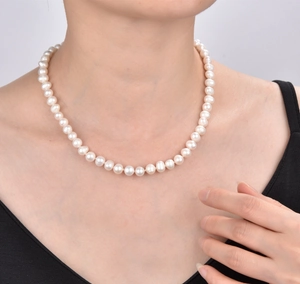 Detailed close-up of a 925 silver freshwater pearl necklace on a female neck