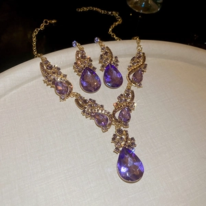 Detail of luxury teardrop purple crystal necklace and earrings set with gold plating