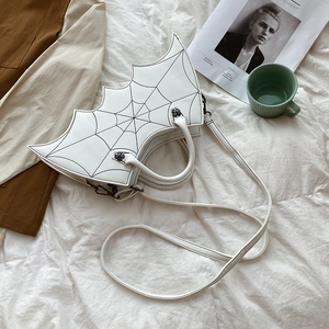 Detailed close-up of white PU leather bat-shaped handbag with spider web stitching and cross