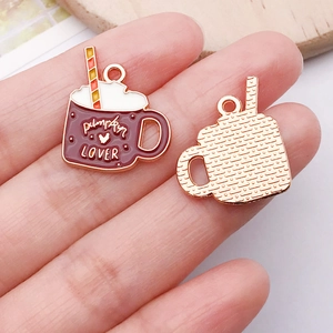 Macro detail of pumpkin coffee cup enamel charm featuring Pumpkin Lover text and gold metal