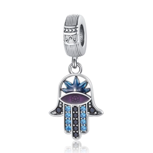 Macro shot of silver Hamsa charm with blue star, purple eye and embedded crystals