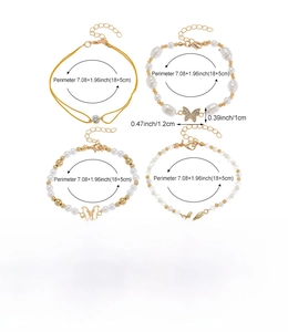 Detailansicht eines 4-teiligen Armbandsets mit Schmetterlingsanhängern und Perlen auf Weiß
