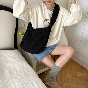 Detailed view of the black bubble textured fabric on a large capacity crossbody bag