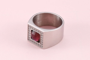 Macro shot of silver signet ring with square red gemstone and micro-pave crystals