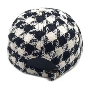 Detail of adjustable metal buckle and vintage houndstooth texture on the wool baseball cap