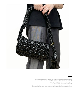Detailed view of the woven oil wax leather texture and knot detail on the black hobo bag