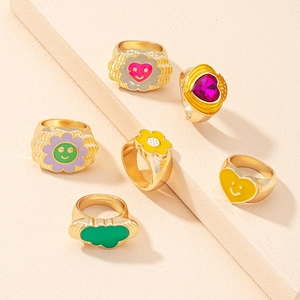 Close-up of gold-plated alloy rings with colorful enamel heart and flower designs