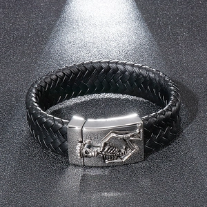 Macro view of woven black leather bracelet with a steel skull magnet clasp detail