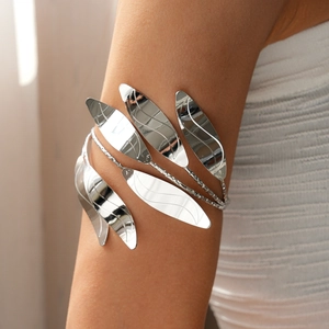 Close-up of a silver layered leaf arm cuff with a polished metallic mirror finish