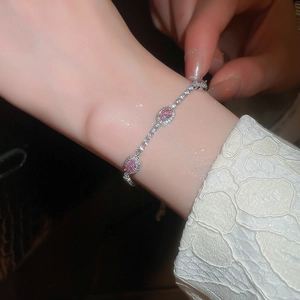 Macro shot of silver-tone adjustable bracelet with sparkling pink oval zircon stones