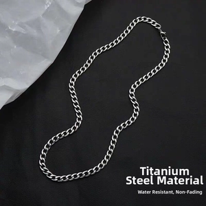 Close-up of silver titanium steel Cuban link chain necklace on textured background