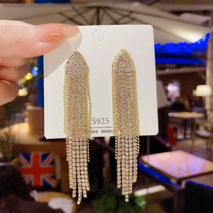 Detailed macro of S925 silver needle rhinestone tassel earrings held in hand