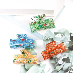Glittery acrylic Christmas hair claws featuring snowman and reindeer patterns