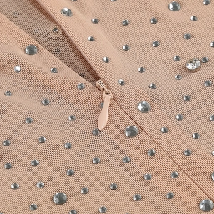 Macro shot of nude mesh fabric with sparkling silver rhinestones and invisible zipper detail