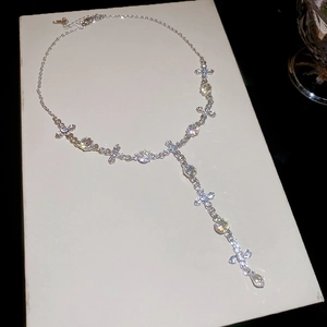 Macro shot of Y-shaped necklace with crystal crosses and a teardrop pendant
