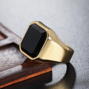 Detailed close-up of men's gold plated signet ring featuring a black step-cut square stone