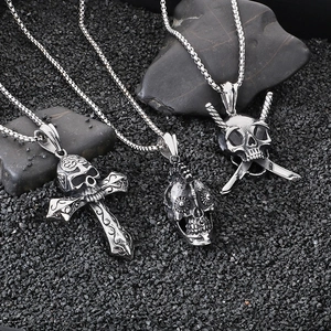 Punk gothic skull and cross stainless steel pendants on black stone background
