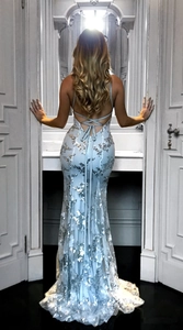Detail of cross-back lace-up straps on light blue sequin mermaid evening gown