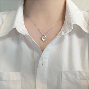 Close-up of irregular heart pendant 925 silver necklace worn by model on white shirt