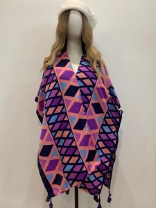 Detail of bohemian geometric print shawl with purple and blue tones and fringe trim
