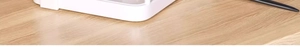 Detailed close-up of white storage rack corner on a wooden surface with a black pen