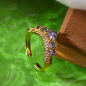 Macro shot of gold adjustable ring with purple heart zircon and pave crystals