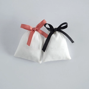 White velvet drawstring jewelry pouches with elegant pink and black ribbon bows