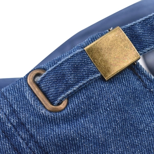 Detail of the adjustable bronze metal buckle and blue washed denim strap on the cap