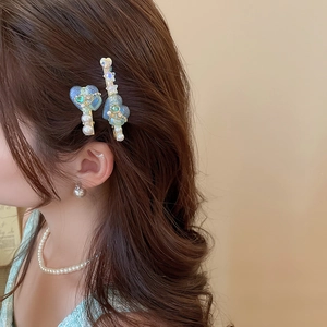 Détail du clip à cheveux en forme de cœur avec perles et cristaux sur les cheveux du modèle