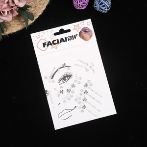 Clear adhesive facial gemstones and silver crystals on white card for creative makeup