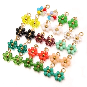 Detail of DIY floral pendants with colorful glass beads and golden metal ear hooks