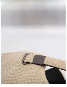 Detail of adjustable metal buckle on beige woven baseball cap for custom sizing