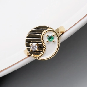 Macro view of gold-plated enamel evil eye ring with white dripping oil and green gemstone